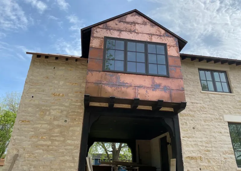 Copper metal panel facade on a stone building for Roof Repair in Sienna